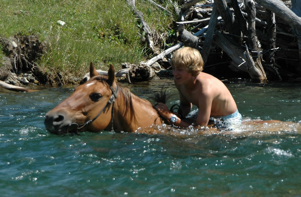 Sweet Grass Ranch Fording a Stream on Horseback